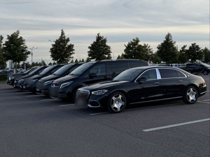 Чёрный Maybach и пять чёрных минивэнов V-класс в ряд на парковке