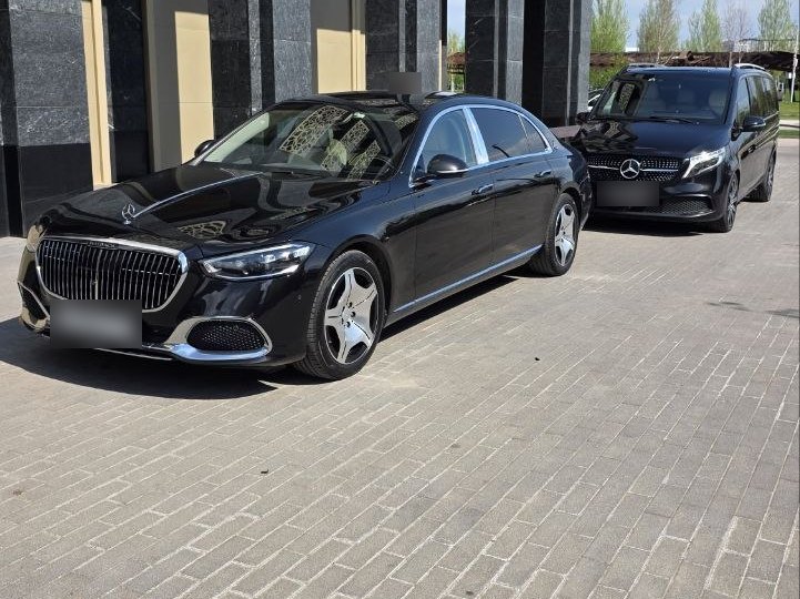 Чёрный Mercedes-Maybach Z223 и минивэн V-класс у входа в здание